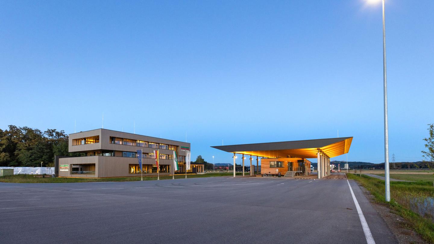 The new office building of HASSLACHER PREDING Holzindustrie, entrance with terminal at dusk