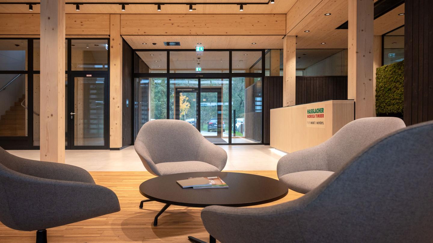 The new office building of HASSLACHER PREDING Holzindustrie, interior seating area and entrance in the background