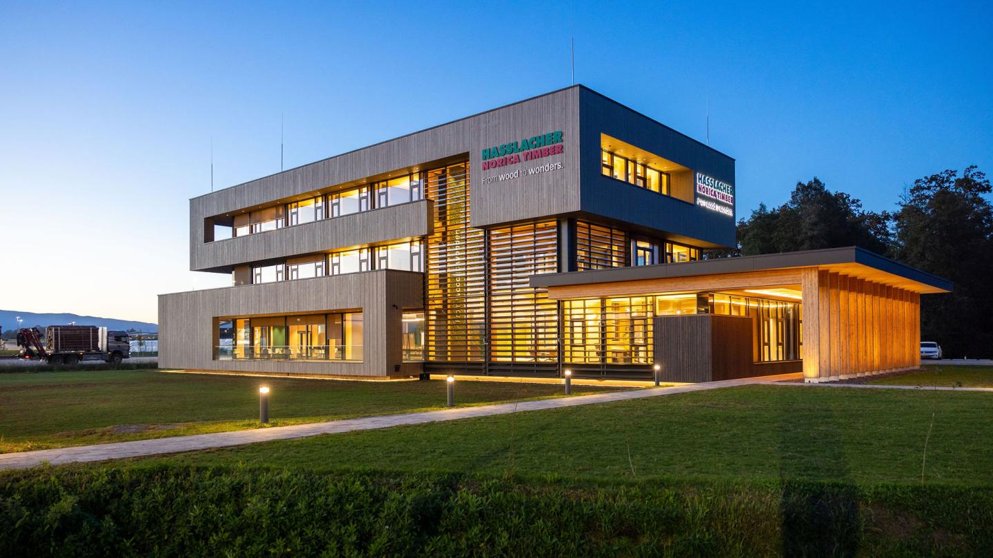 The new office building of HASSLACHER PREDING Holzindustrie, exterior view at dusk with lighting