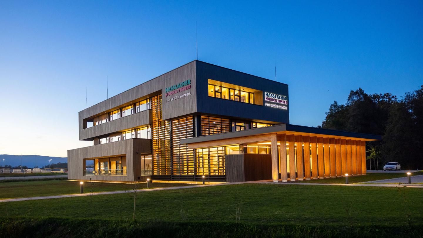 The new office building of HASSLACHER PREDING Holzindustrie, exterior view at dusk with lighting