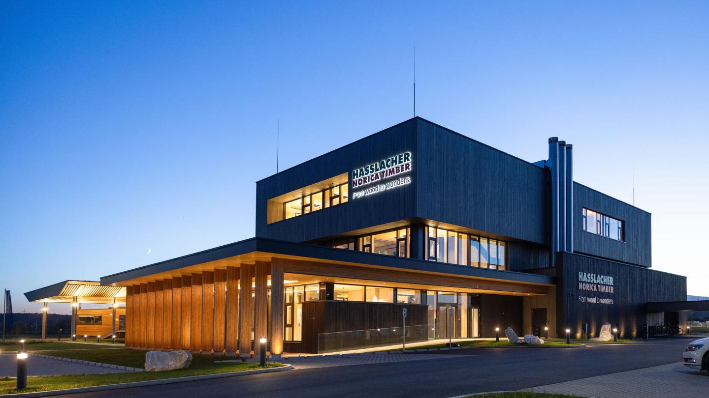 The new office building of HASSLACHER PREDING Holzindustrie, exterior view at dusk with lighting