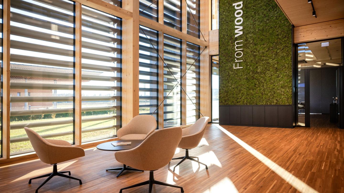 The new office building of HASSLACHER PREDING Holzindustrie, interior entrance area in daylight with moss wall and logo