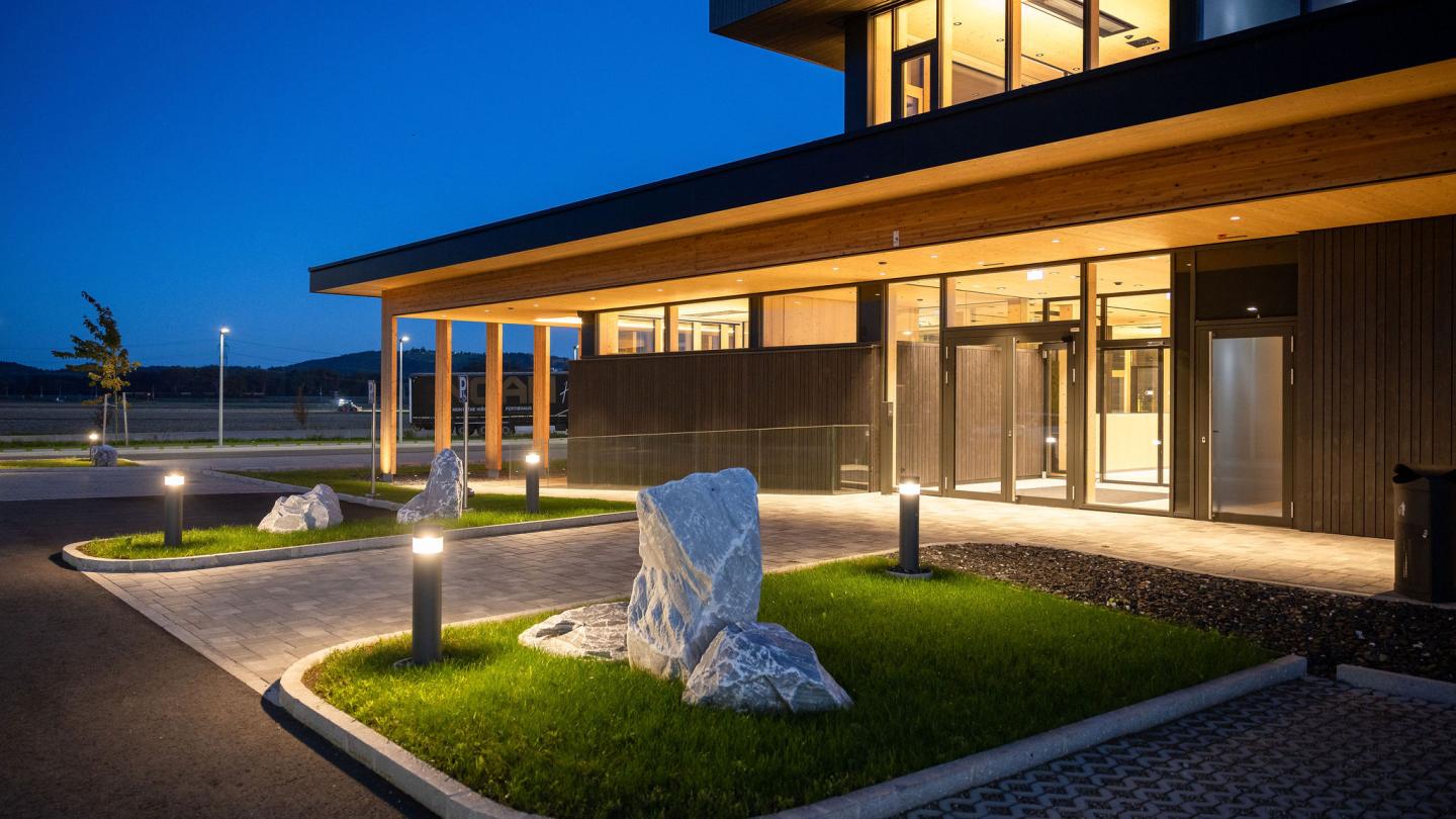 The new office building of HASSLACHER PREDING Holzindustrie, entrance at dusk with lighting