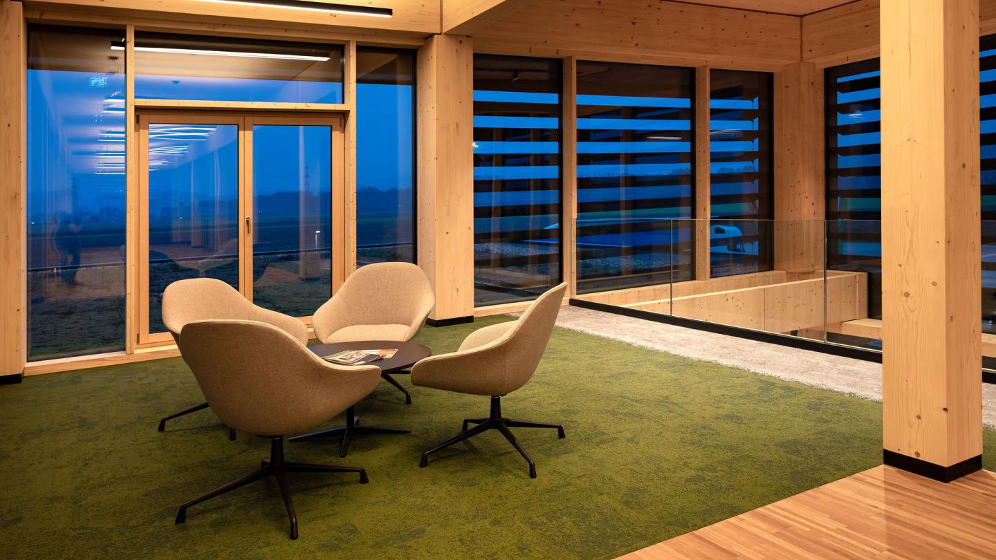 The new office building of HASSLACHER PREDING Holzindustrie, interior seating area at dusk