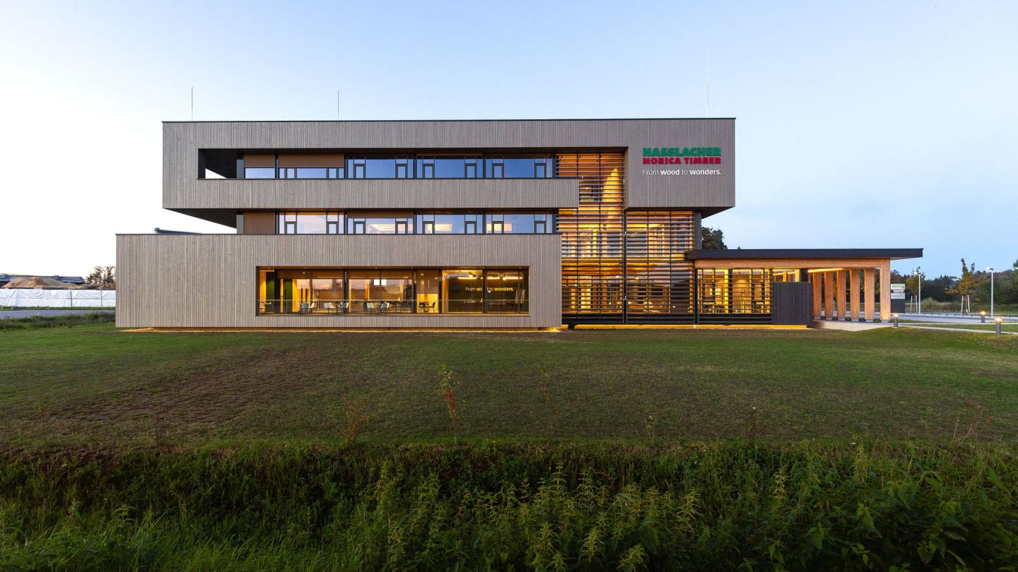 The new office building of HASSLACHER PREDING Holzindustrie, exterior view in daylight with lighting