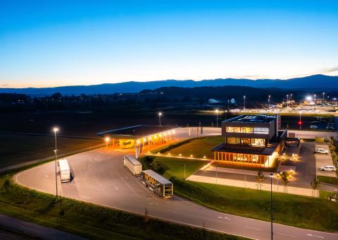 The new office building of HASSLACHER PREDING Holzindustrie, terminal and office building at dusk and with lighting