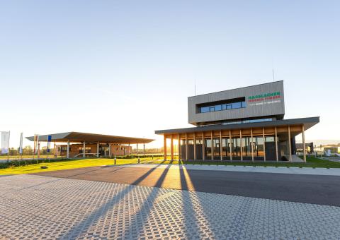 The new office building of HASSLACHER PREDING Holzindustrie, car park in the background office building and terminal