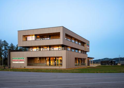 The new office building of HASSLACHER PREDING Holzindustrie, exterior view of terrace and balcony at dusk