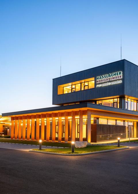 The new office building of HASSLACHER PREDING Holzindustrie, exterior view at dusk with lighting