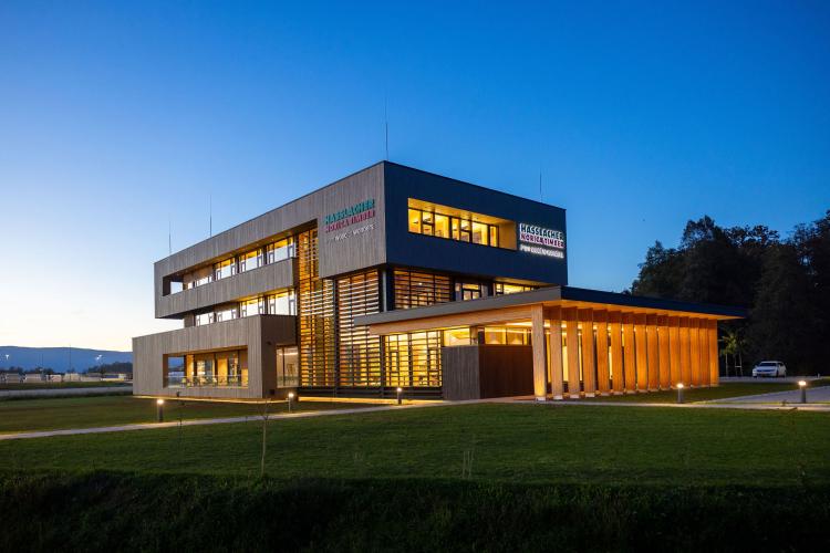 Das neue Bürogebäude der HASSLACHER PREDING Holzindustrie, Außenansicht bei Dämmerung mit Beleuchtung